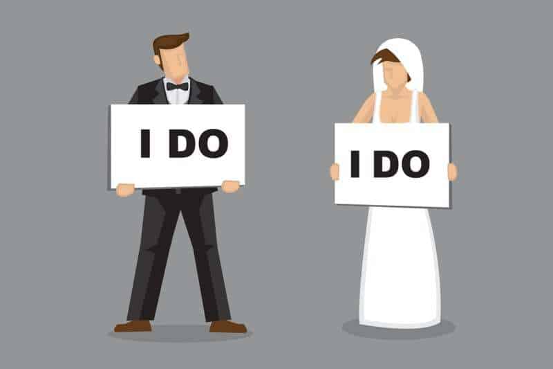 bride and groom both with "i do" signs